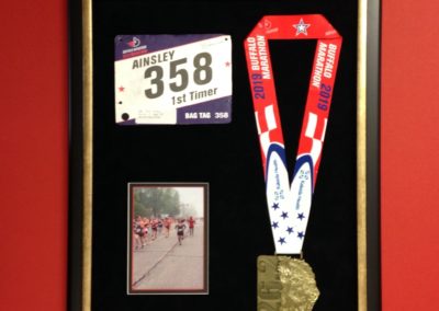 framed running medal and picture